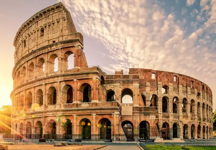 Le Colisée de Rome baigné par le soleil levant, un monument emblématique pour toute visite à Rome.