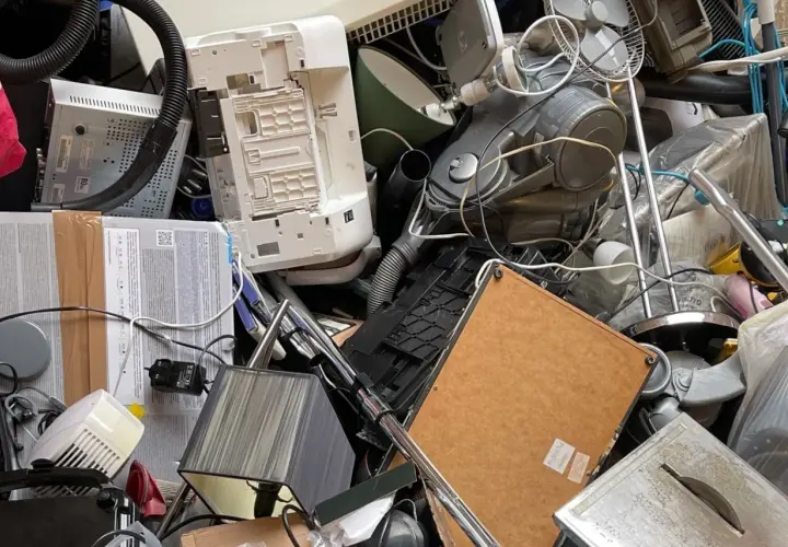 Stos starych urządzeń elektronicznych: drukarka, odkurzacz, wentylator, lampa.