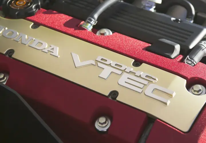 Złota pokrywa silnika Honda z napisem VTEC. To technologia, która zapewnia moc i oszczędność.