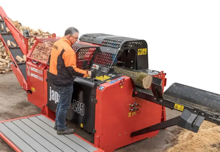 Mann bedient einen BGU Sägespaltautomat, der Holzscheite effizient verarbeitet.