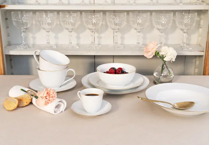 Elegantes schwedisches Porzellan mit goldenen Akzenten, serviert mit Beeren, Kaffee und Gebäck.