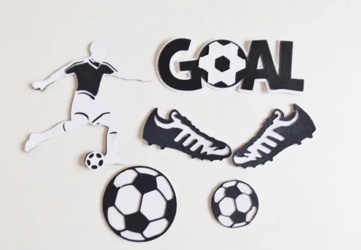 Silueta de futbolista pateando balón, dos botas, tres balones y la palabra "GOAL" en manualidades de fútbol.