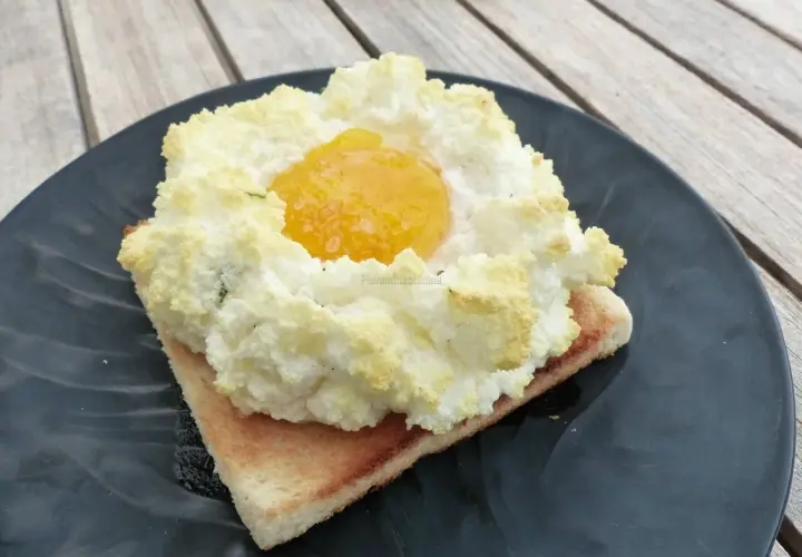 Un œuf nuage aérien sur une tranche de pain grillé, parfait pour une recette légère et gourmande.