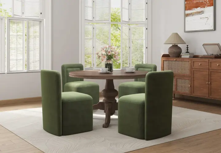 Four green chairs with plush, straight backs surround a round wooden table, showcasing modern types of chair backs.