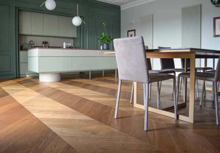 Un elegante soggiorno con cucina moderna e un **miglior parquet** a spina di pesce, che crea un gioco di luci e ombre.