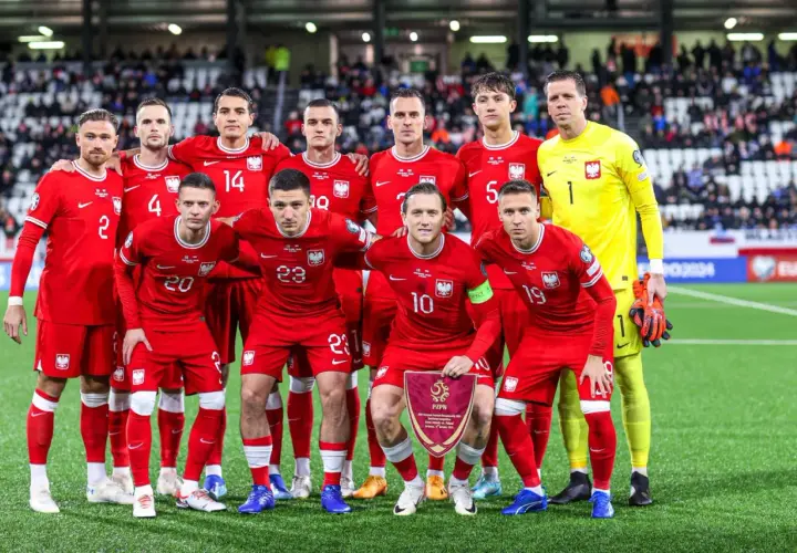 Piłkarze reprezentacji Polski w czerwonych strojach, gotowi do gry. Drużyna, która jak polska wyspy owcze, walczy o zwycięstwo.