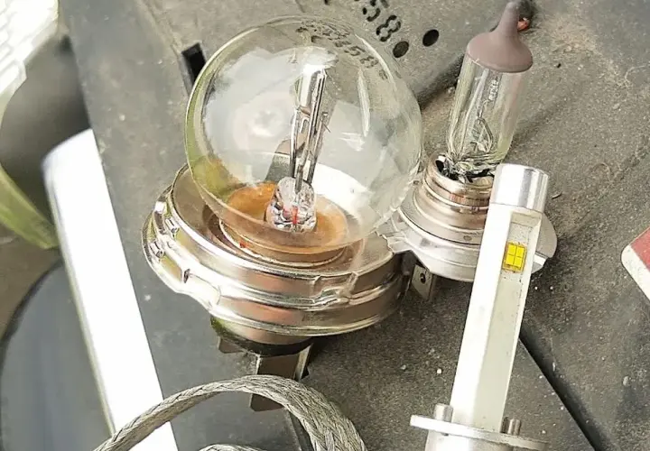 Stare żarówki słabo świecą w domu, obok nowoczesna lampa LED.