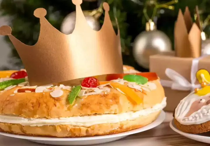 Un gâteau pour accompagner le champagne, décoré de fruits confits et d'une couronne dorée, prêt pour une fête royale.