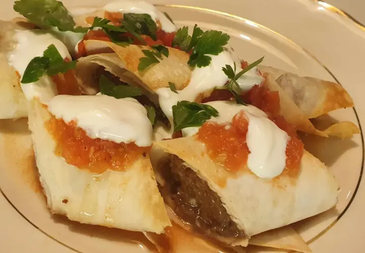 Beyti kebab med yoghurt, tomatsås och persilja. En läcker rätt som ser ut att smaka fantastiskt.