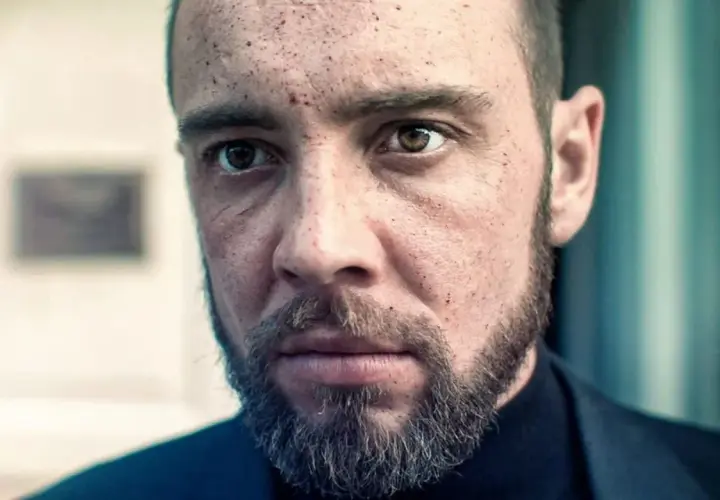 Twarz mężczyzny z zarostem i śladami na skórze, jakby przeżył trudne chwile. Może to scena z filmu "Walden jak zostałem gangsterem".