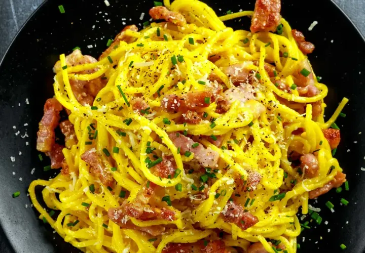 Spaghetti crémeux à la carbonara, garni de lard italien croustillant, de parmesan râpé et de ciboulette fraîche. Un délice !