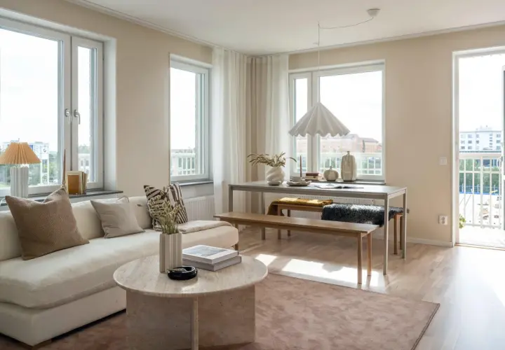 Ljust och luftigt vardagsrum med soffa, soffbord och matplats. Vår inredning skapar en harmonisk och inbjudande atmosfär.