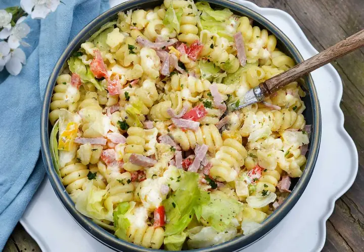 En stor skål med krämig pastasallad med skinka, tomat och sallad. Perfekt dressing till pastasallad för en sommarlunch.