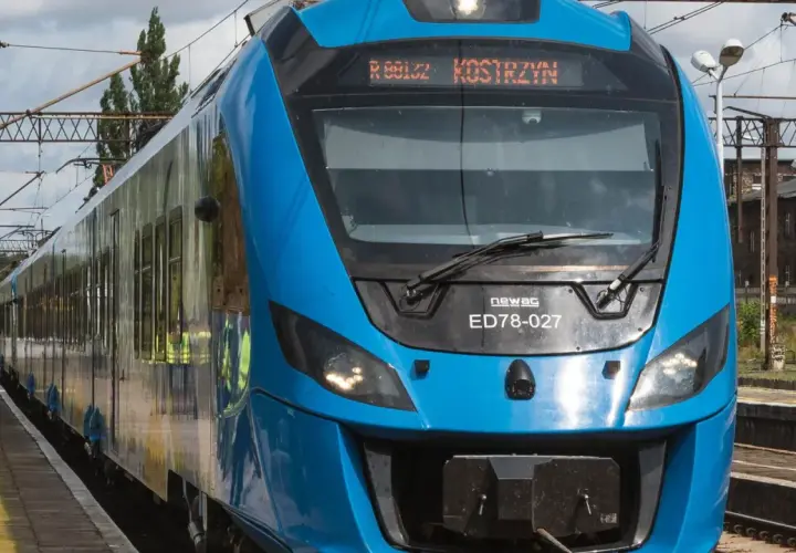 Błękitny pociąg Newag ED78-027 z napisem "Kostrzyn" na wyświetlaczu, gotowy do podróży z Berlina.