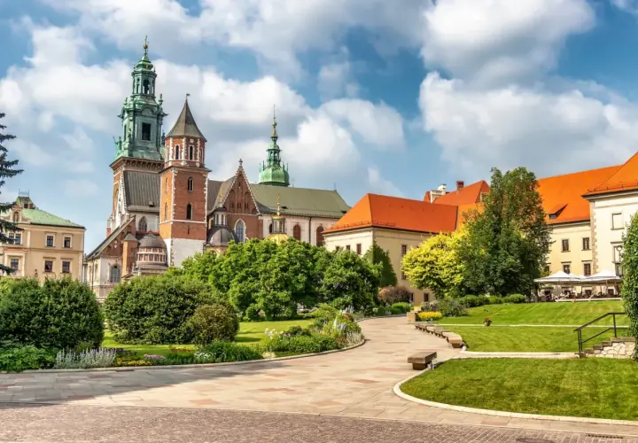 Piękny dzień na zwiedzanie Wawelu. Majestatyczna katedra i zamkowe budowle otoczone zielenią.