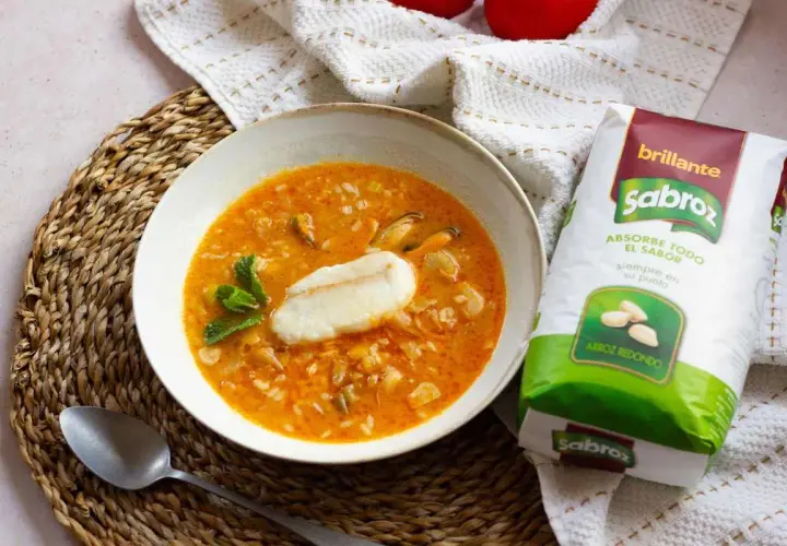 Sopa de pescado con arroz sencilla, con trozos de pescado, mejillones y arroz redondo Sabroz, decorada con menta.