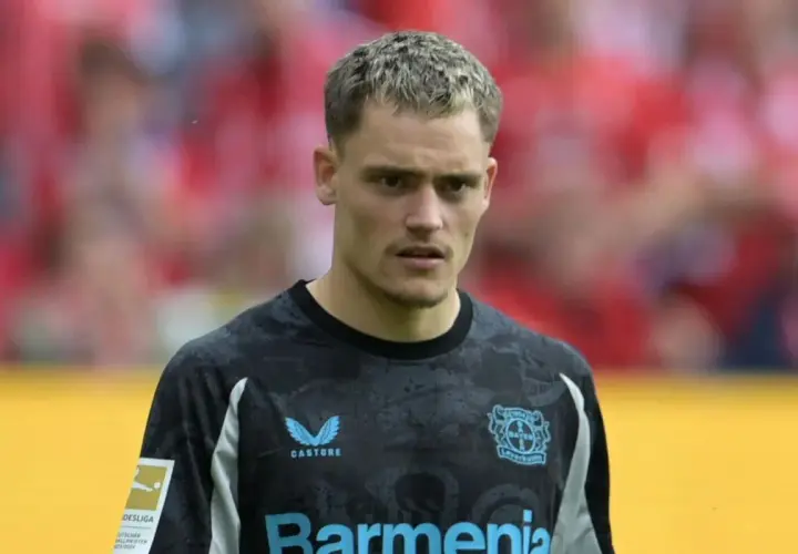 Bramkarz Bayer Leverkusen w nowym stroju, gotowy na kolejne transfery i sukcesy.