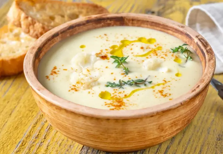 Un onctueux potage Dubarry, garni de chou-fleur, d'huile d'olive et de thym, servi avec des toasts grillés.