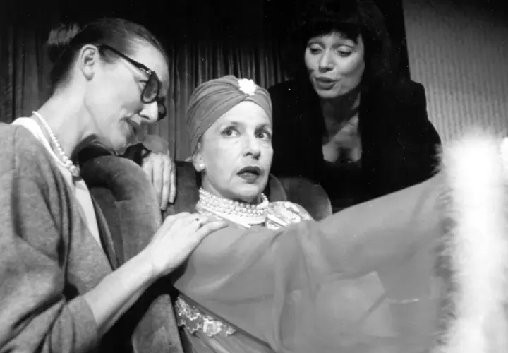 Marlena Milwiw młoda, w turbanie i perłach, z dwiema kobietami u boku, w teatralnej scenie.