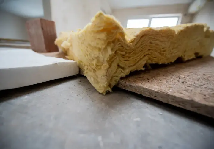 Warstwa wełny mineralnej, styropianu i płyty OSB – materiały do ocieplania budynków.
