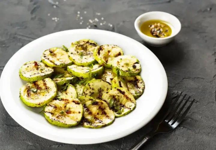 Zucchine alla scapece non fritte, grigliate e condite con erbe aromatiche e olio. Un piatto leggero e saporito.