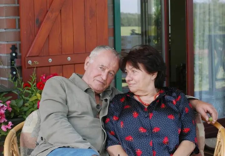 Para siedzi na werandzie. Mężczyzna ma siwe włosy, kobieta ciemne. Nie wiadomo, ile lat ma Anna Kondratowicz.