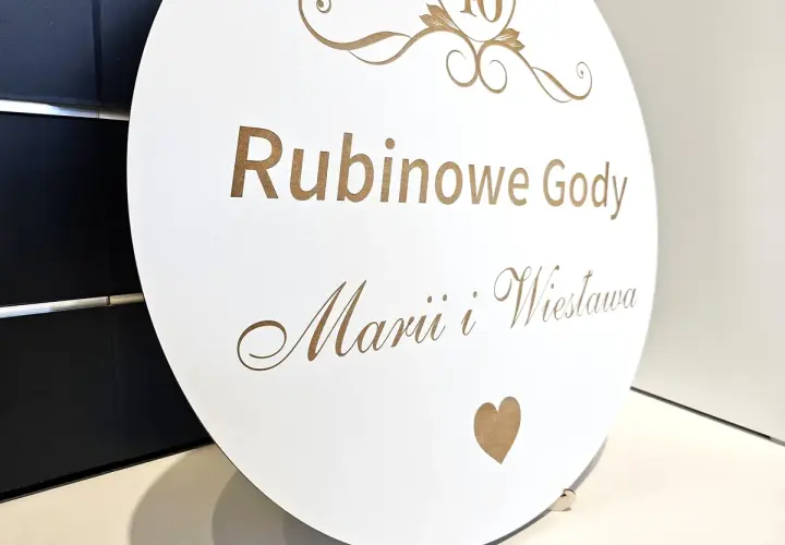 Okrągła tablica z napisem "Rubinowe Gody Marii i Wiesława" i cyfrą 40. Piękne życzenia na 40 rocznicę ślubu.