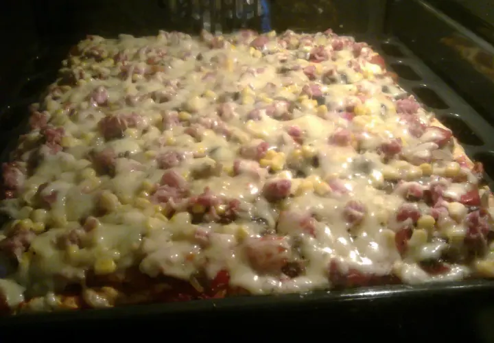 Pyszna pizza z kukurydzą i wędliną, właśnie wyjęta z piekarnika. Ania gotuje i tworzy cuda!