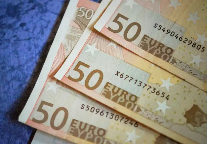 Trois billets de 50 euros sont empilés sur un fond bleu. Le coût de la vie est élevé, on est condamné aux dépens.