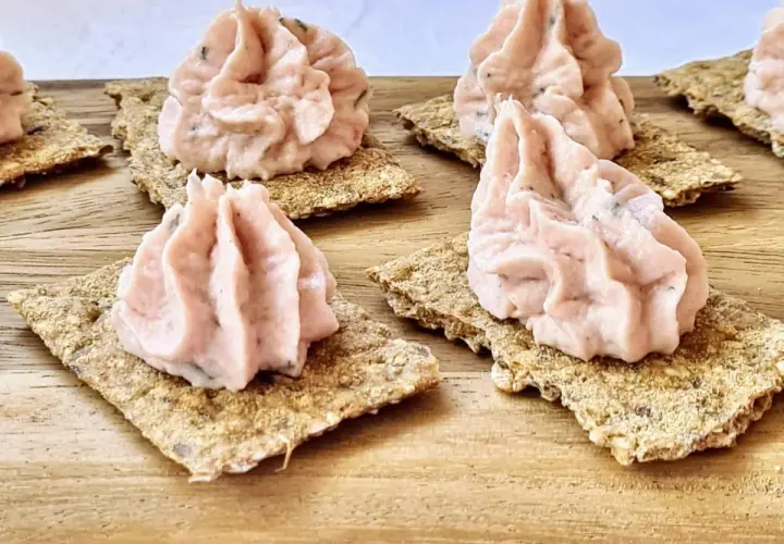 Petites bouchées de rillettes de jambon onctueuses sur des crackers croustillants, prêtes à être dégustées.