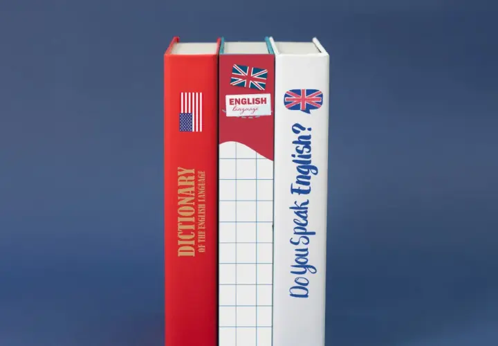 Tre libri: un dizionario di inglese, uno con bandiera britannica e uno con la domanda "Do you speak English?".