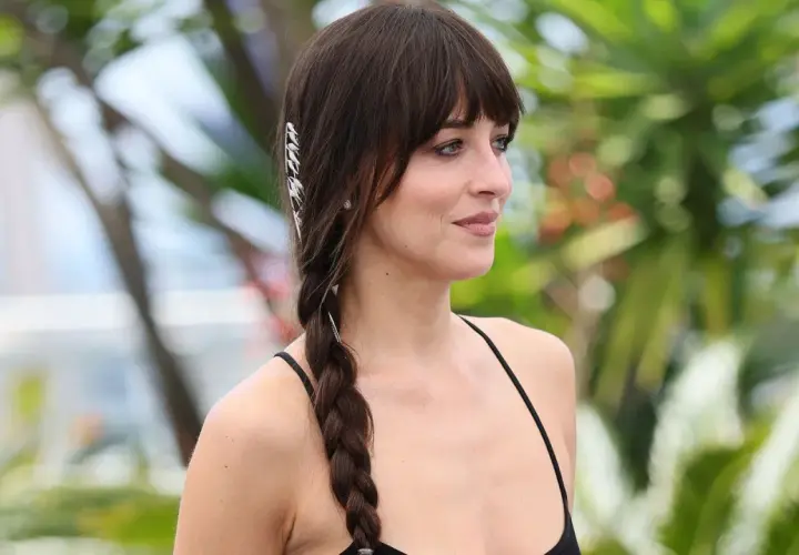 Mujer con flequillo y una trenza lateral adornada con accesorios plateados, luciendo unas trenzas de moda.