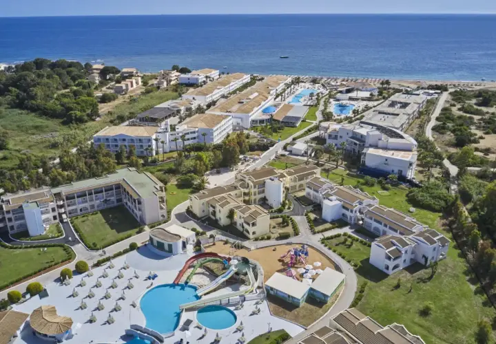 Widok z lotu ptaka na kompleks hotelowy z basenami, zjeżdżalniami i placem zabaw, blisko plaży. Wiele budynków, zieleni i morza. Idealne miejsce na wakacje, zgodnie z labranda sandy beach resort opinie.