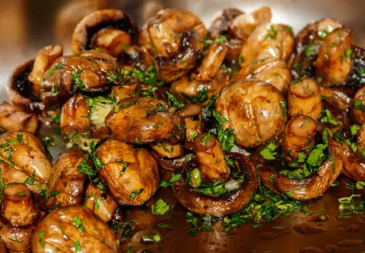 Champignons sautés, brillants et garnis de persil frais. Une recette simple et savoureuse pour sublimer ce légume.