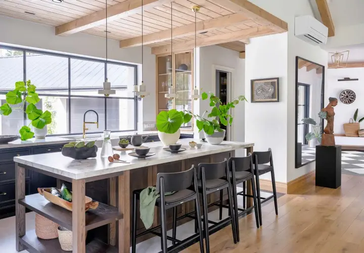 Nowoczesna kuchnia w stylu **styl modern farmhouse** z wyspą, marmurowym blatem, drewnianymi belkami i dużą ilością zieleni.