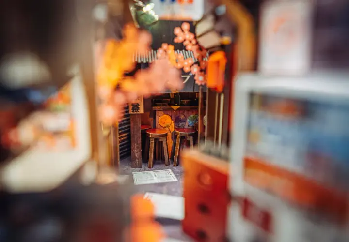 Miniaturowy japoński zaułek z dwoma stołkami, idealny do stworzenia własnego **diy book nook**.