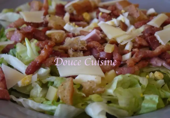 Salade savoyarde généreuse avec lardons, fromage, œuf dur et croûtons. Un délice pour les papilles.