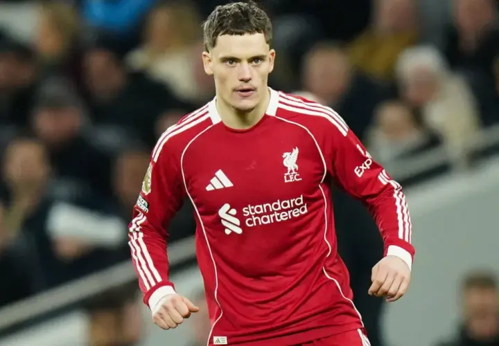 Piłkarz Liverpoolu w czerwonej koszulce, gotowy do gry. Jego determinacja może wpłynąć na rankingi Liverpoolu.