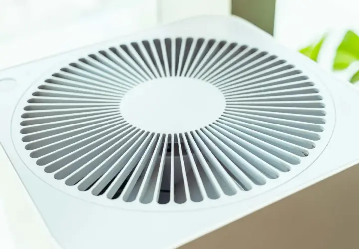Purificador de aire blanco con rejilla circular. Considera las contraindicaciones del purificador de aire para un uso seguro y efectivo.