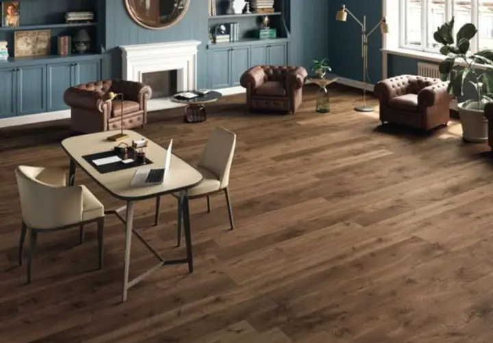 Un elegante soggiorno con camino, poltrone in pelle e un tavolo da lavoro. Il pavimento in legno scuro, perfetto per la posa pavimenti, completa l'arredamento.