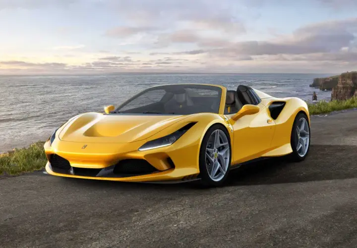 Żółte Ferrari F8 Spider na tle klifów i oceanu.