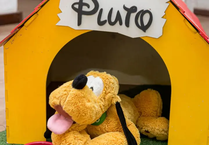 Pluszowy piesek Pluto, jeden z ulubionych bohaterów z bajek, leży w swojej żółtej budzie.