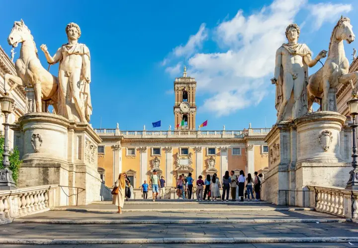 Devant les musées du Capitole, des statues équestres majestueuses encadrent une foule admirative.