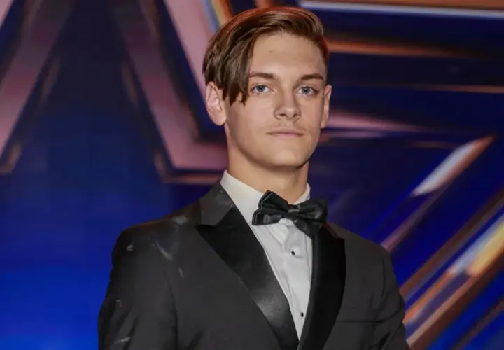 Młody mężczyzna w garniturze i muszce, gotowy na występ w Mam Talent 2024.