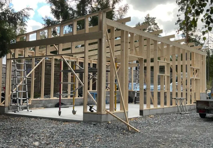 Trästomme till ett garage under uppbyggnad. Grunden är gjuten och stommen reses, vilket ger en bra uppfattning om bygga garage kostnad.