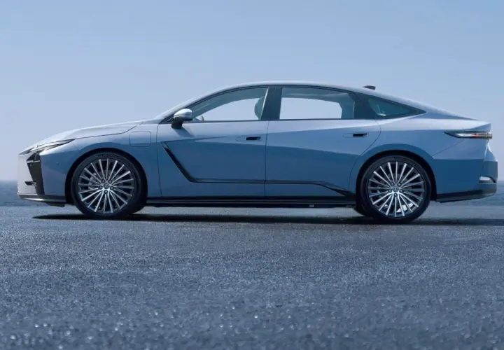 Nowy Lexus ES w błękitnym kolorze, prezentujący swoją elegancką sylwetkę na tle błękitnego nieba i morza.