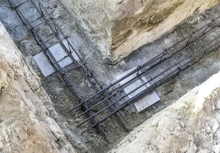 Gotowe zbrojenie fundamentu w wykopie. Stalowe pręty tworzą solidną konstrukcję, gotową na zalanie betonem.