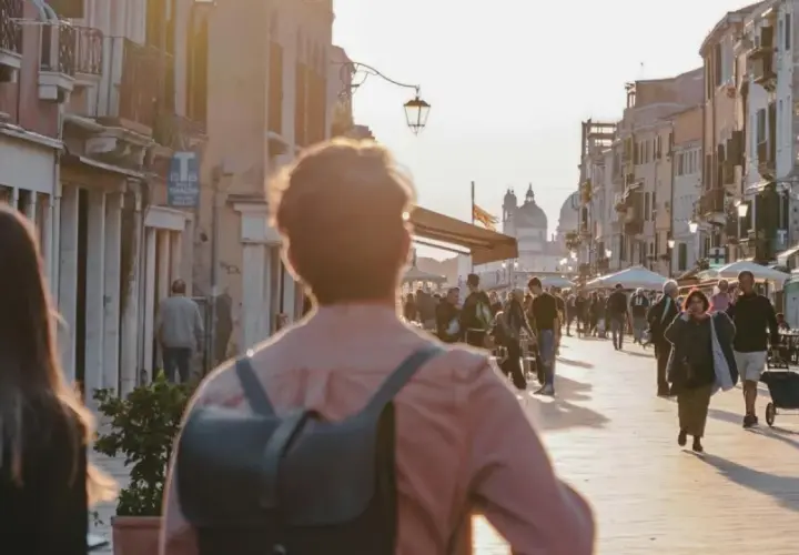 Promenade animée à Venise, près du Campo dei Mori, au coucher du soleil. Des passants flânent le long des bâtiments colorés.