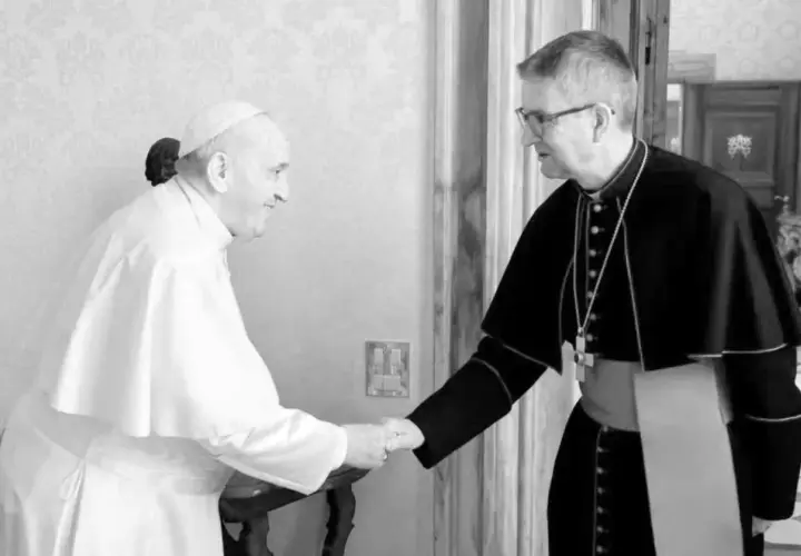 Papst Franziskus, seit wann ist Franziskus Papst, schüttelt einem Bischof die Hand.