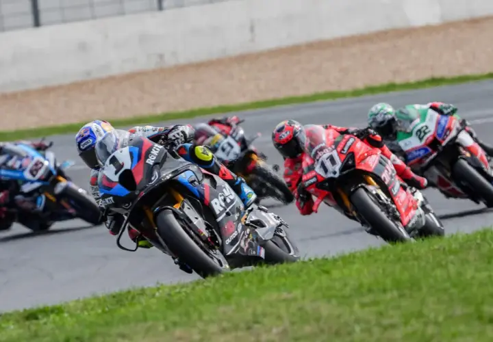 Pilotos de superbikes compiten en una carrera, inclinándose en una curva. ¡Emoción pura donde ver superbikes!
